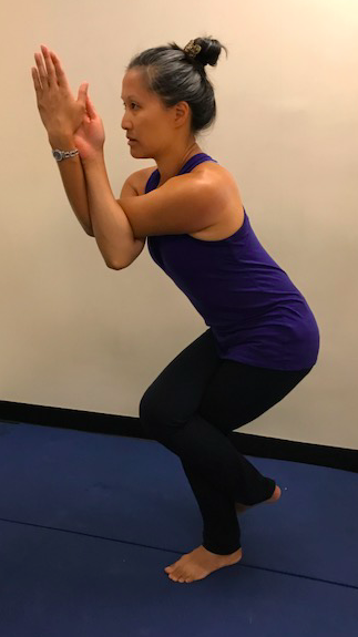 Person doing Eagle Pose on blue mat