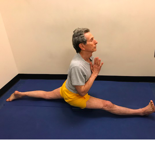 Man doing splits on blue mat