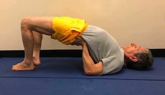 Man practicing bridge pose on mat