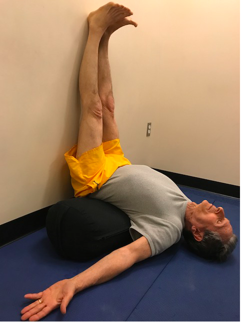 Man doing yoga legs-up-the-wall pose