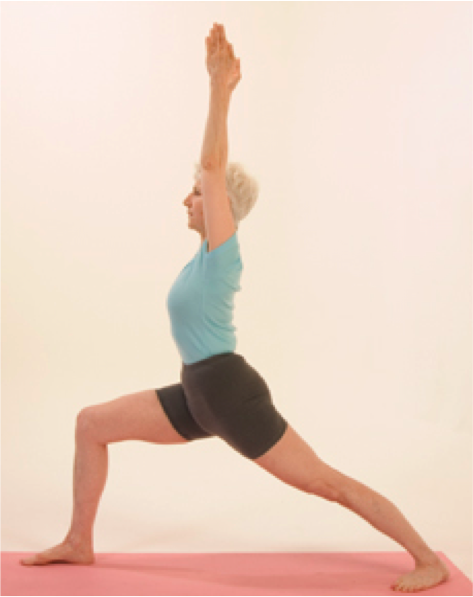 Woman practicing Warrior I yoga pose