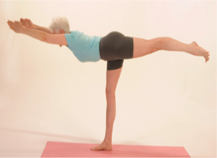 Woman practicing yoga on a pink mat.