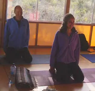 Two people practicing yoga indoors