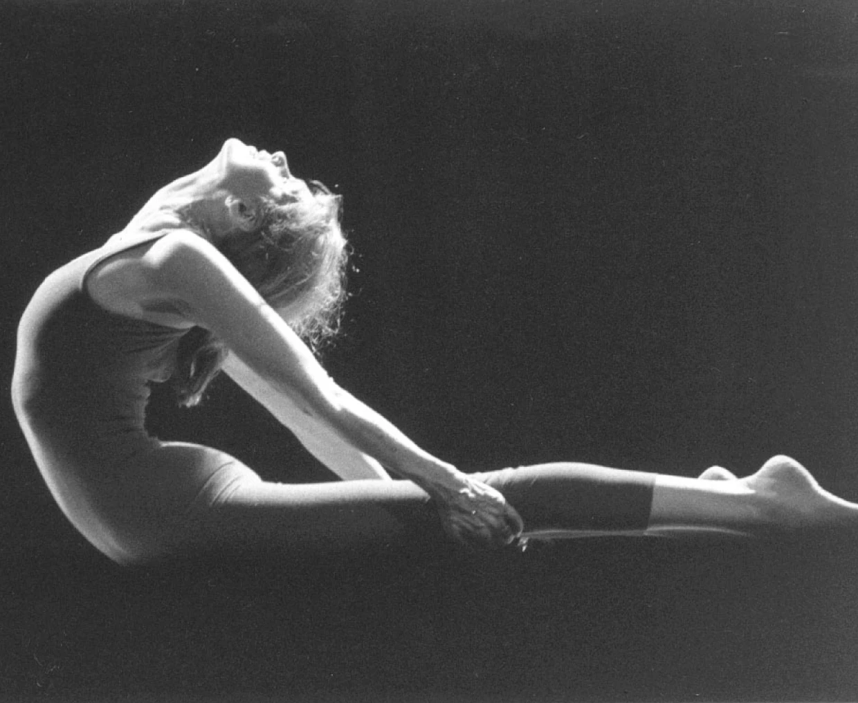 Artistic yoga pose in silhouette lighting.