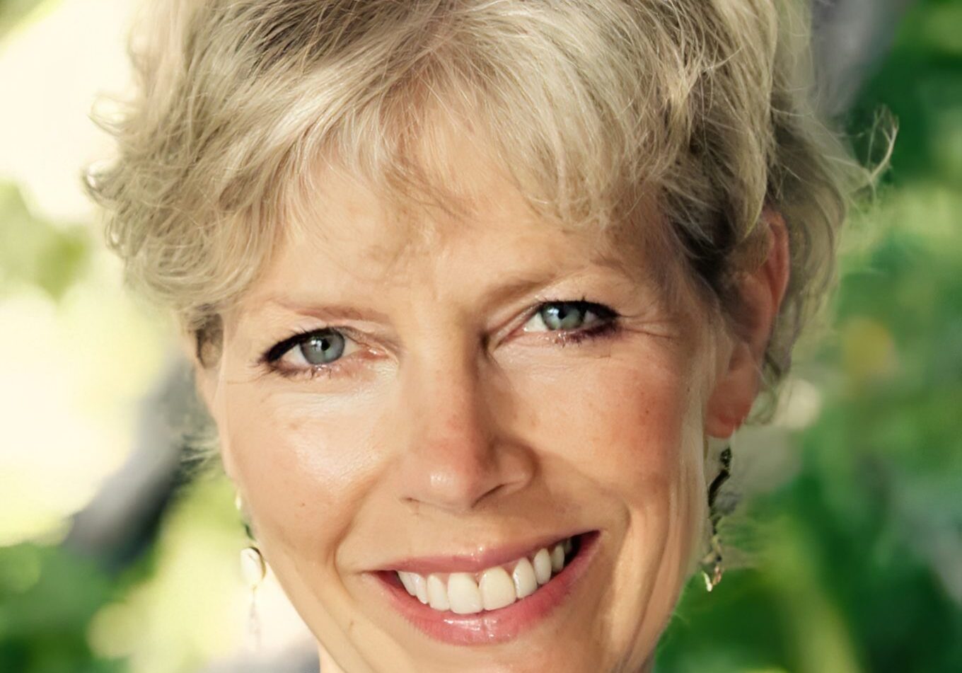 Happy woman with earrings and green background