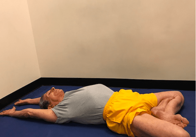 Individual practicing yoga in a small room