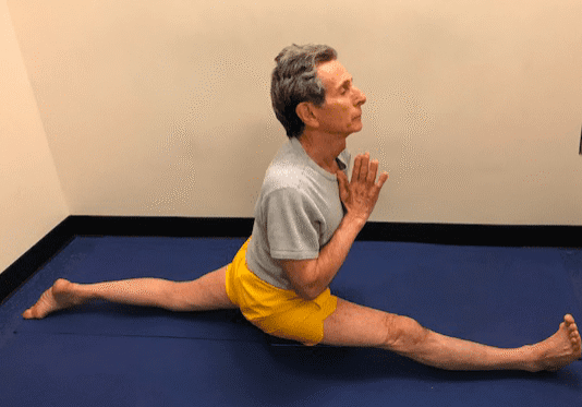 Man doing splits on blue mat