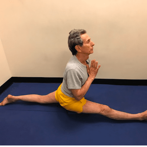 Man doing splits on blue mat