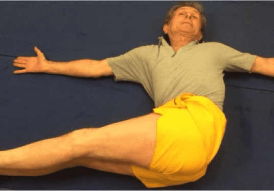 Individual wearing yellow shorts stretching