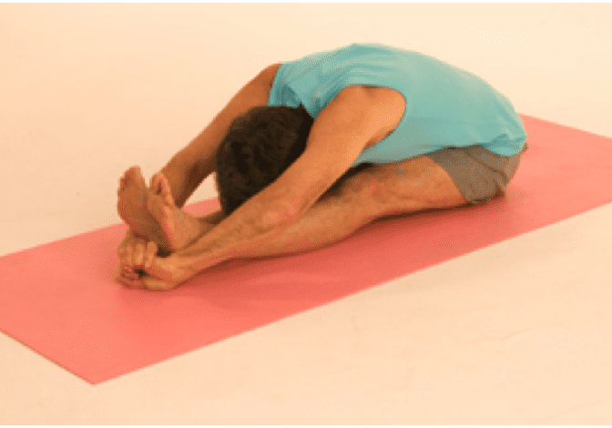 Man doing seated forward bend yoga pose