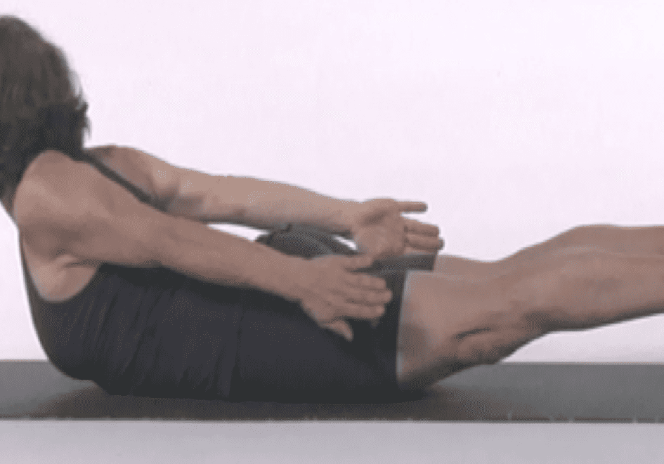Woman performing yoga pose on mat