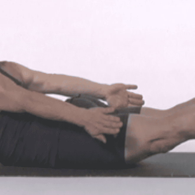 Woman performing yoga pose on mat