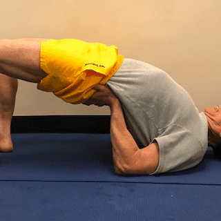 Man practicing bridge pose on mat
