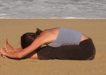 Woman doing yoga on the beach