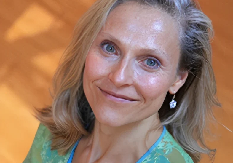 Woman wearing green top, smiling