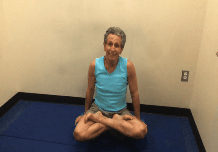 Person meditating in turquoise tank top