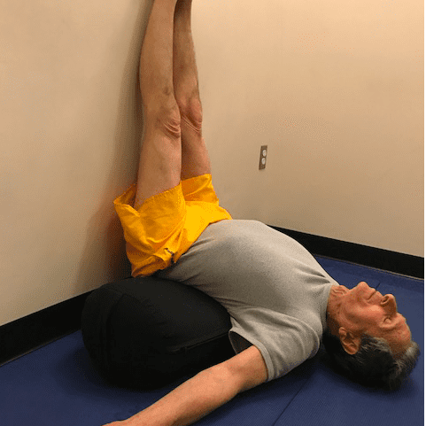 Man doing yoga legs-up-the-wall pose