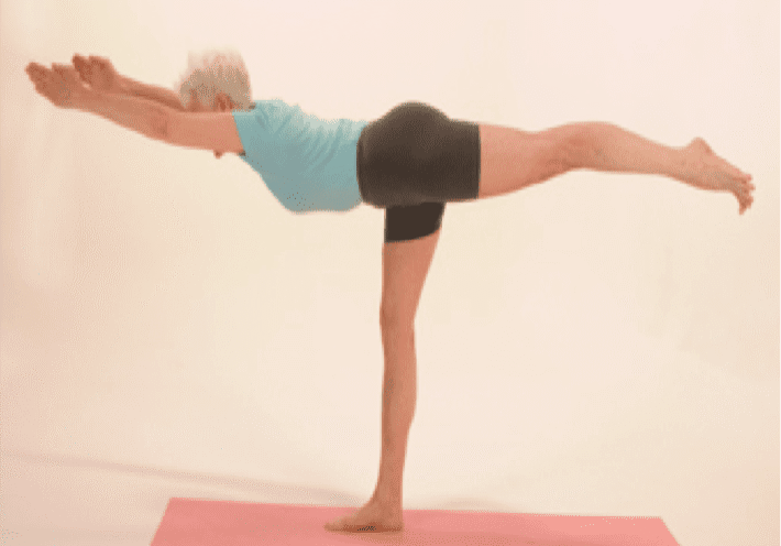 Woman practicing yoga on a pink mat.